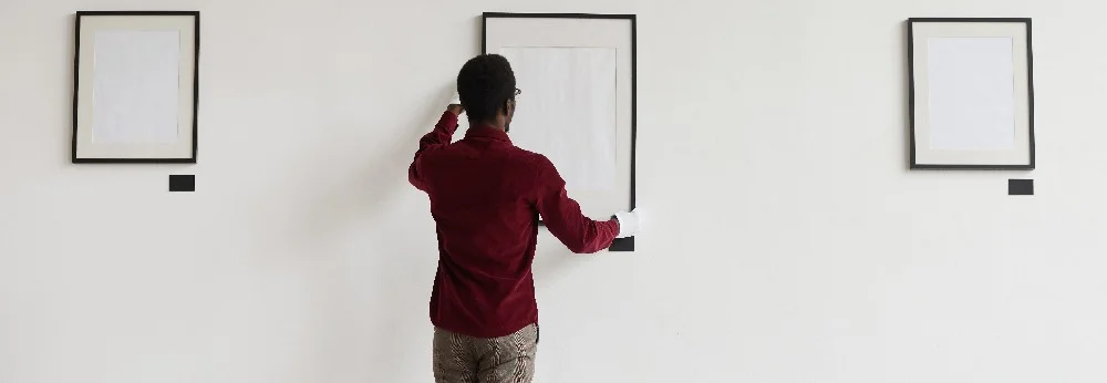 Person hängt Bild auf